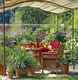 Středomořské rostliny v květináčích, proutěný zahradní nábytek a pergola promění hodiny na zahradě v malou dovolenou. Středomořské rostliny v květináčích, proutěný zahradní nábytek a pergola promění hodiny na zahradě v malou dovolenou.