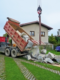 Doprava velkých a hmotných materiálů na zahradu vypadá dramaticky, ale když se vše pohlídá, není to velký problém. Na obrázku Tatra vysypává žulové balvany na trávník a plastové zatravňovací rošty. Pokud pod kameny položíte alespoň nějaké desky a trámky, obejde se i taková akce bez větších škod. Počítejte ale s tím, že auto váží 10 tun a náklad dalších 10–15 tun. Díky velkému počtu kol se váha dobře rozloží, podmínkou je však suché počasí. Doprava velkých a hmotných materiálů na zahradu vypadá dramaticky, ale když se vše pohlídá, není to velký problém. Na obrázku Tatra vysypává žulové balvany na trávník a plastové zatravňovací rošty. Pokud pod kameny položíte alespoň nějaké desky a trámky, obejde se i taková akce bez větších škod. Počítejte ale s tím, že auto váží 10 tun a náklad dalších 10–15 tun. Díky velkému počtu kol se váha dobře rozloží, podmínkou je však suché počasí.
