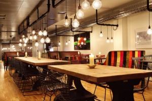 Interiér restaurace V je pojatý jako studentský a velmi uvolněný. Dlouhé dubové stoly doplňují designové židle a křesla. Interiér restaurace V je pojatý jako studentský a velmi uvolněný. Dlouhé dubové stoly doplňují designové židle a křesla.