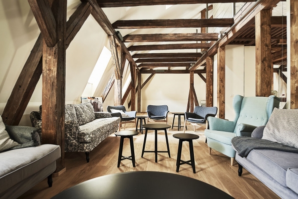 Zrekonstruované podkroví je vybaveno nábytkem v retro stylu a slouží k relaxaci. Historický krov architekti zkombinovali s moderními konstrukčními prvky ze skla a oceli. Zrekonstruované podkroví je vybaveno nábytkem v retro stylu a slouží k relaxaci. Historický krov architekti zkombinovali s moderními konstrukčními prvky ze skla a oceli.